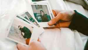 Wczesne objawy Alzheimera. Mózg je zdradza, gdy odpoczywasz. Na zdjęciu: człowiek trzyma zdjęcia młodych ludzi