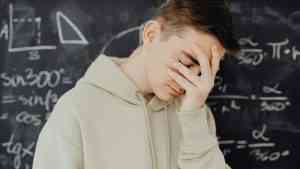 Uczeń stojący przed tablicą