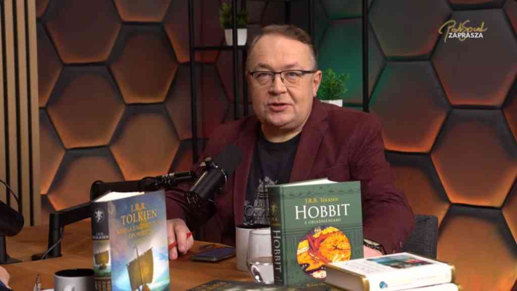 półzbliżenie na twarz mężczyzny na ciemnym tle obok dwie książki