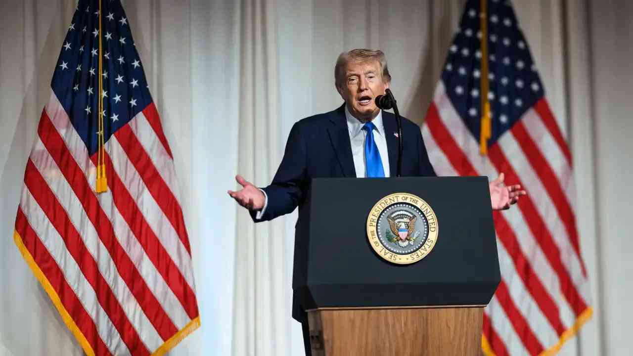 Donald Trump przemawia przy prezydenckiej mównicy na tle amerykańskich flag. Zdjęcie ilustruje tekst o drugiej kadencji Trumpa, wojnie z Iranem i sporze wokół jego politycznych obietnic.