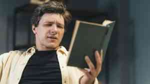 mężczyzna czytający książkę – książki pisane przez AI i ich odbiór