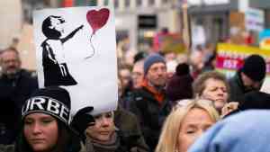 Manifestanci trzymający plakat dziecka z sercem symbolizują wołanie o współczucie w polityce