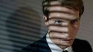 twarz mężczyzny w garniturze , który rzuca cień wskazując na relację: osobowość a wybór kariery