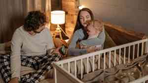 Rodzice usypiający dziecko zastanawiają się czy dzieci dają szczęście?