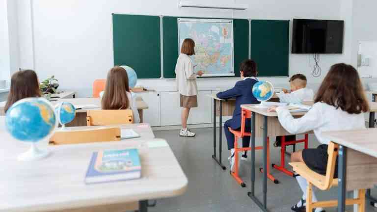 Uczniowie i nauczycielka w klasie na tle tablicy. Twoje 1,5 proc. z PIT może wesprzeć edukację i kulturę