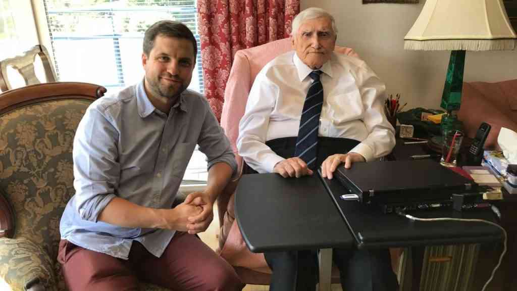 Patrick Ney siedzi przy biurku z prof. Witoldem Kieżunem, Powstańcem Warszawskim