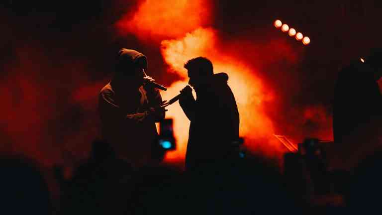 Raperzy na scenie ilustrujący, jak stereotypy fanów muzyki wpływają na postrzeganie innych ludzi przez pryzmat ich muzycznego gustu.
