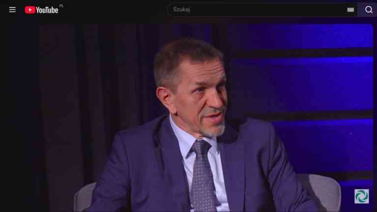 Prof. Jarosław Flis w studiu nagraniowym. Grafika ilustruje wywiad na temat polskiej polaryzacji i konfliktów społecznych.