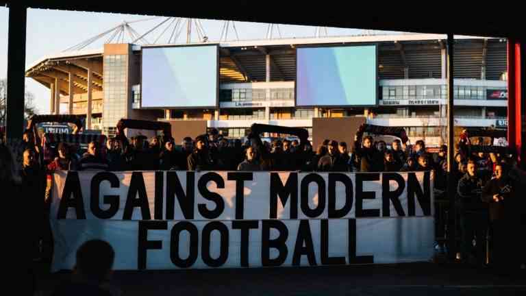 Kibice z transparentem "Against Modern Football" – obraz komercjalizacji piłki nożnej, która budzi bunt.