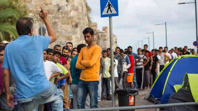 Imigracja w Europie. Grupa migrantów stoi w kolejce przy namiotach, obraz ilustrujący skutki migracji w Europie i politykę migracyjną UE.