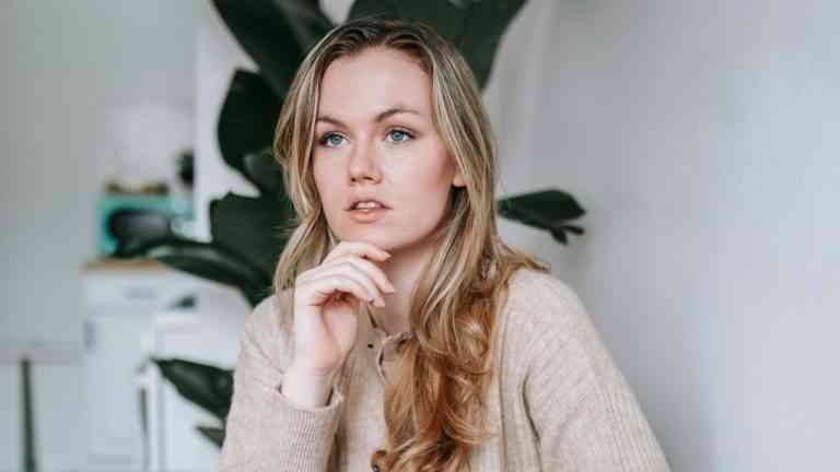 blondynka podpiera głowę ręką i myśli