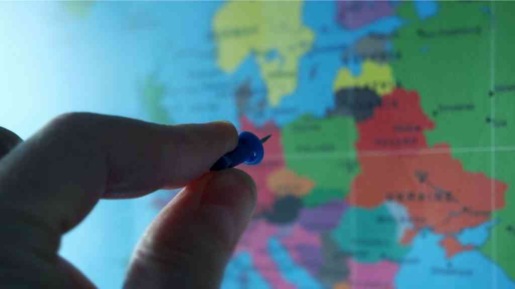 mapa Europy z morzem Bałtyckim pinezka trzymana na wprost w dwóch palcach