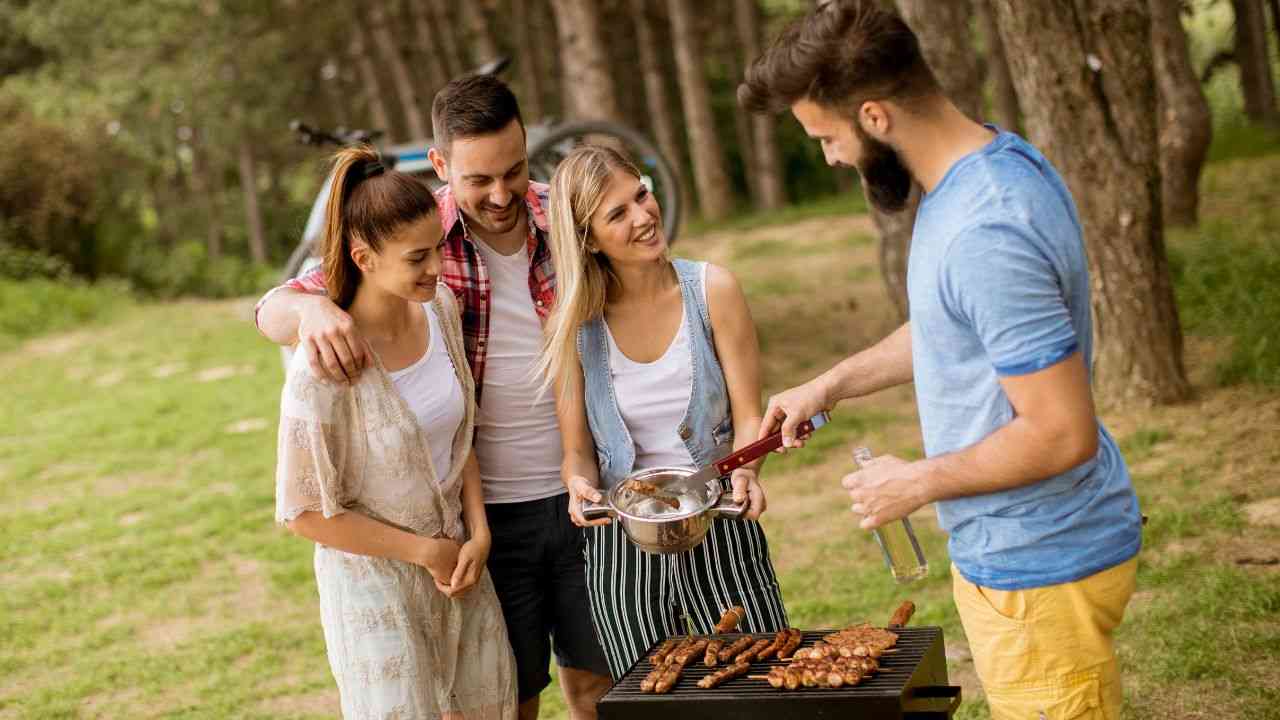 młodzi ludzie stoją przy grillu, co pokazuje, jak dobieramy przyjaciół