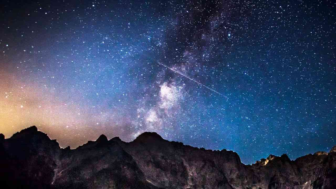 spadające gwiazdy na ciemnoniebieskim niebie widoczne zza gór przedstawiają zjawiska astronomiczne w Polsce