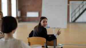 Studentka podczas zajęć w sali wykładowej pokazuje, jak zmieniają się oczekiwania wobec wykładowcy