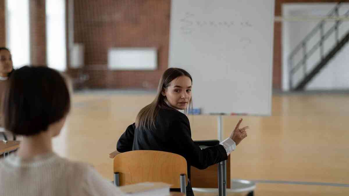 Studentka podczas zajęć w sali wykładowej pokazuje, jak zmieniają się oczekiwania wobec wykładowcy