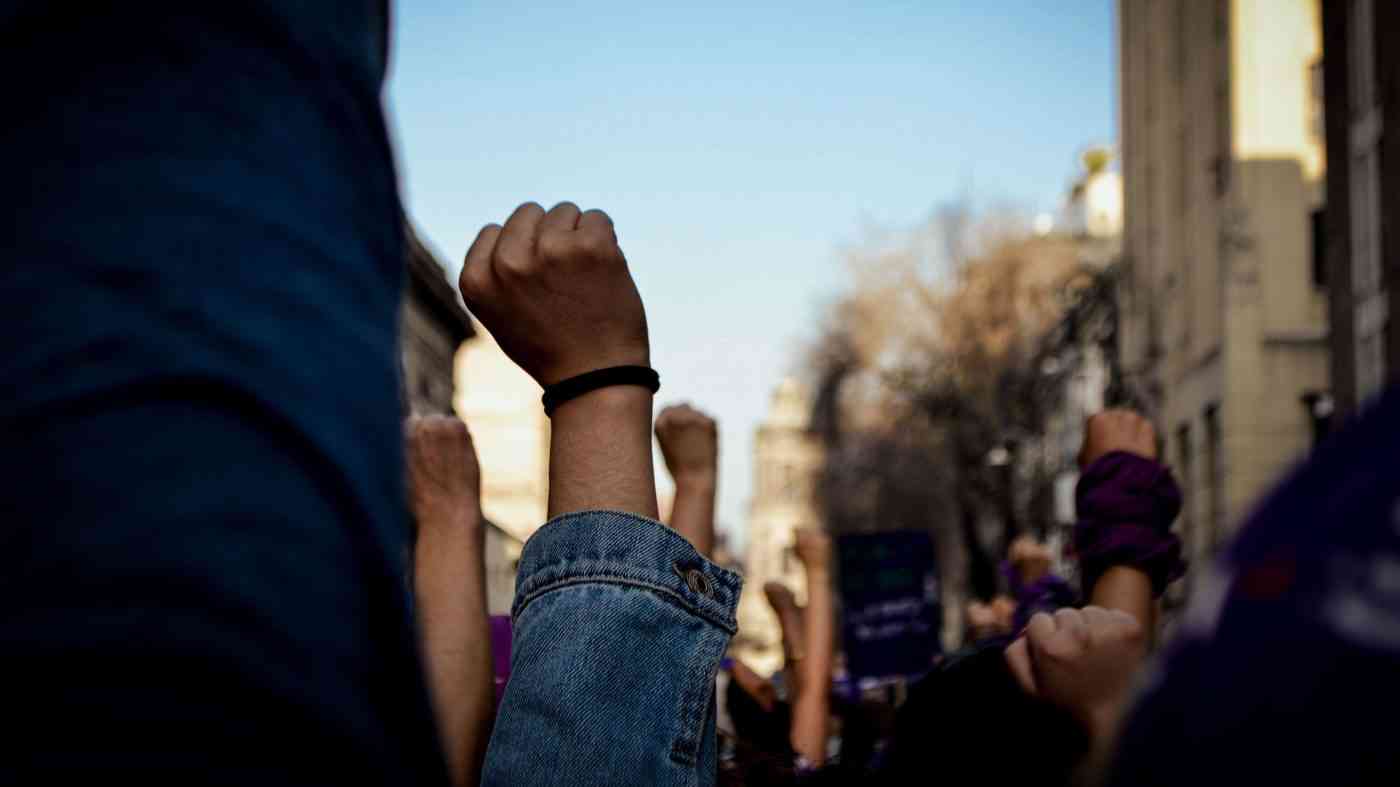 Wzniesione pięści na demonstracji, skłaniające do pytania: dlaczego ludzie protestują na ulicach?