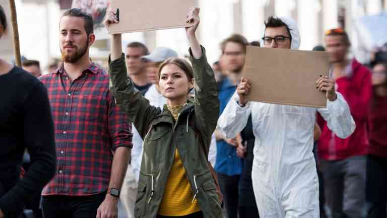 tłum idzie i protestuje, co pokazuje zjawisko polaryzacji zaufania społecznego