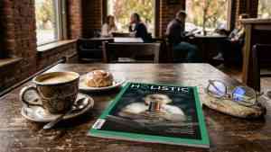 Nowy numer Holistic News na kawiarnianym stoliku