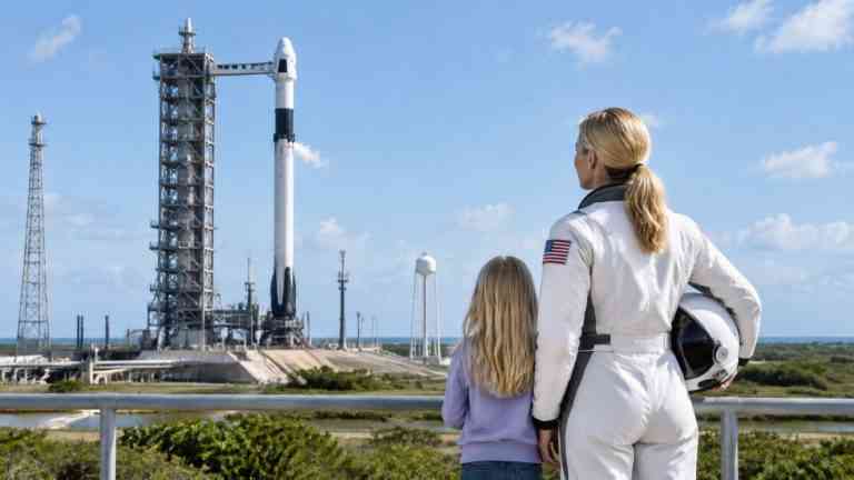 Astronautka z córką obserwują rakietę przed startem — skutki lotów kosmicznych dla kolejnych pokoleń.